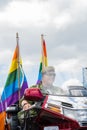 Woman dressed in military style riding motorbike with rainbow during Stockholm Pride Parade